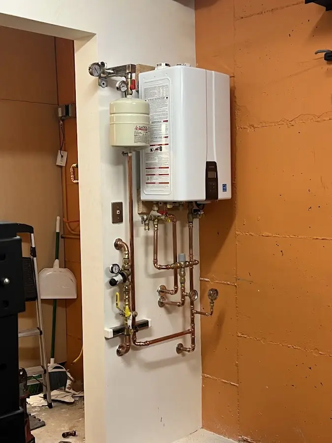 Plumbing technician inspecting water heater connections in Wadsworth